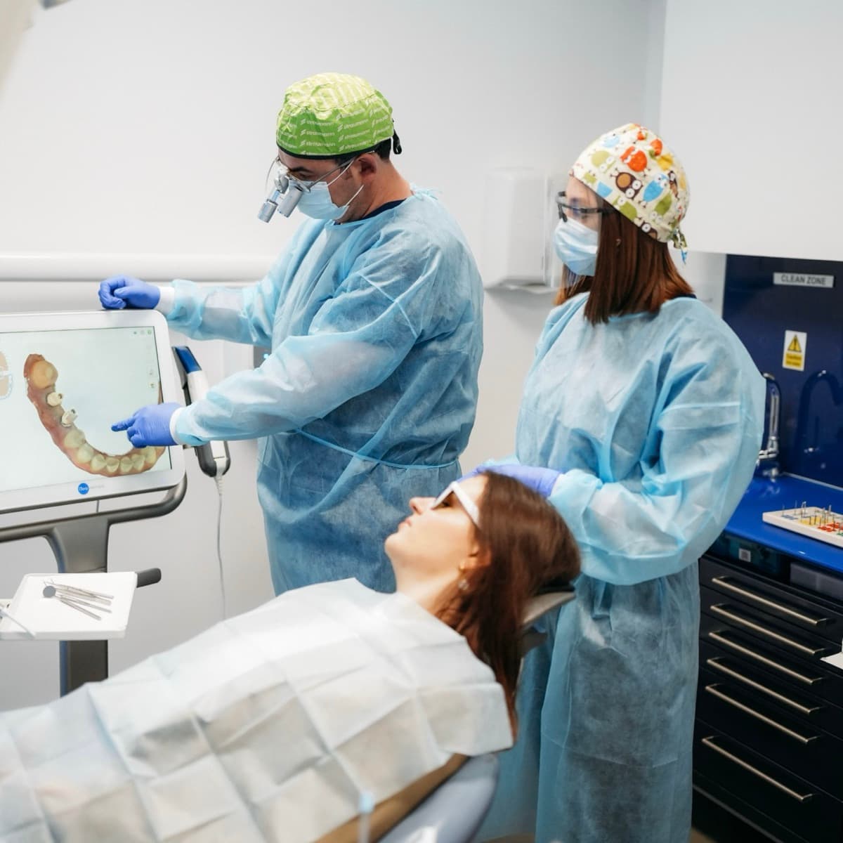 A dentist at London Smile Studio reviews a digital scan of the patient's teeth with them before treatment.